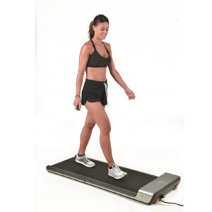 Mergina, besitreniruojanti ant Toorx WALKINGPAD G bėgimo takelio, kuris atrodo kaip kilimėlis.